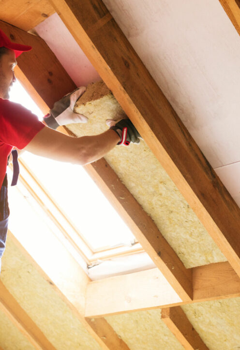 house attic insulation - construction worker installing rock wool in mansard wall house attic insulation - construction worker installing rock wool in mansard wall